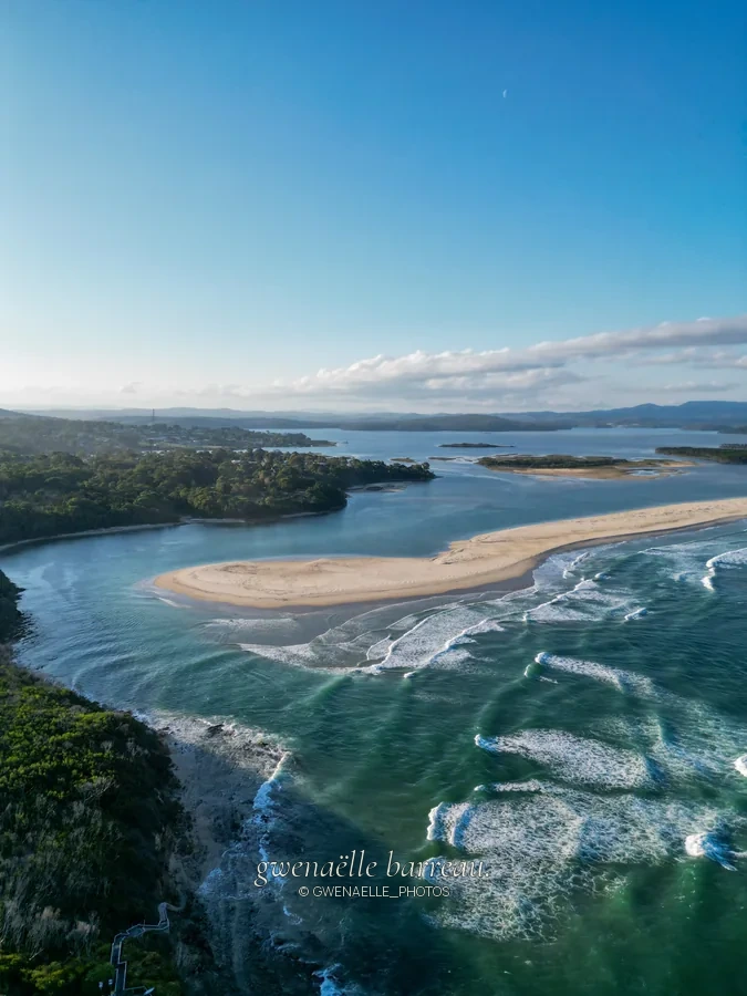 Estuaire aux bancs de sable clairs rejoignant l'océan, vu du ciel.