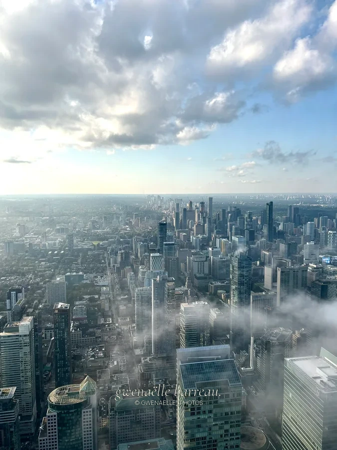 Gratte-ciel et rues d'une grande ville aperçus à travers les nuages.