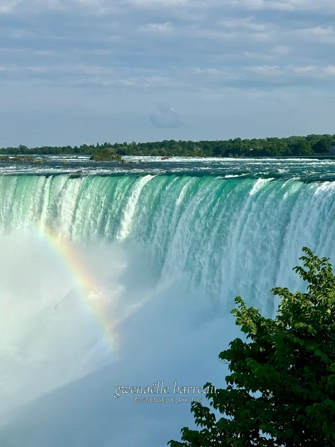 Large chute d'eau et arc-en-ciel au-dessus des embruns.