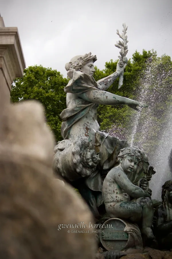 Statues d'une fontaine traversées par des jets d'eau.