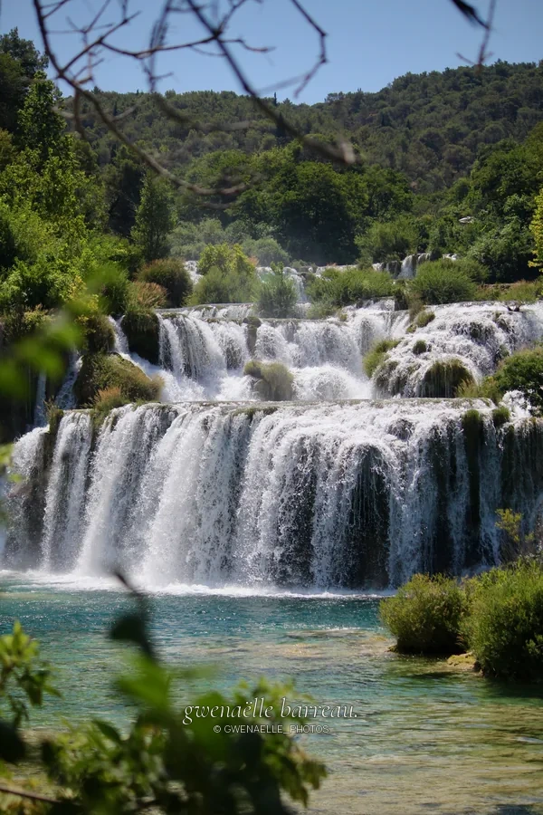 Larges cascades étagées au milieu d'une forêt verdoyante.